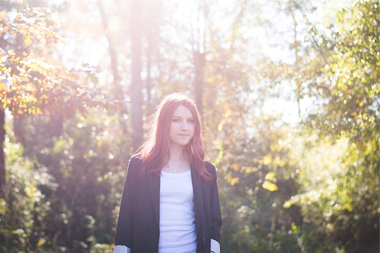 A woman in the sunlight with an oversized blazer and basic white tee 