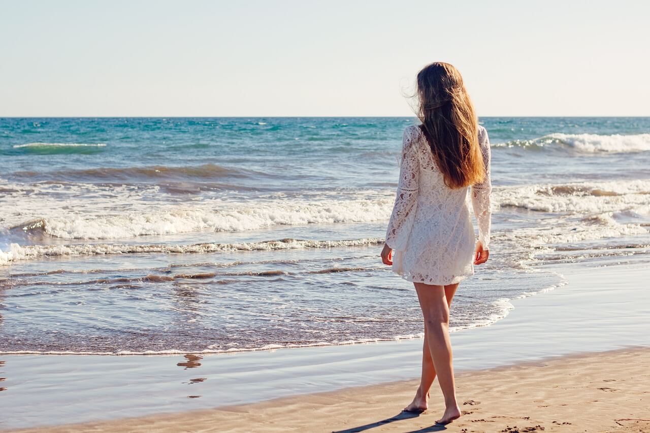 Young woman walking along the beach 